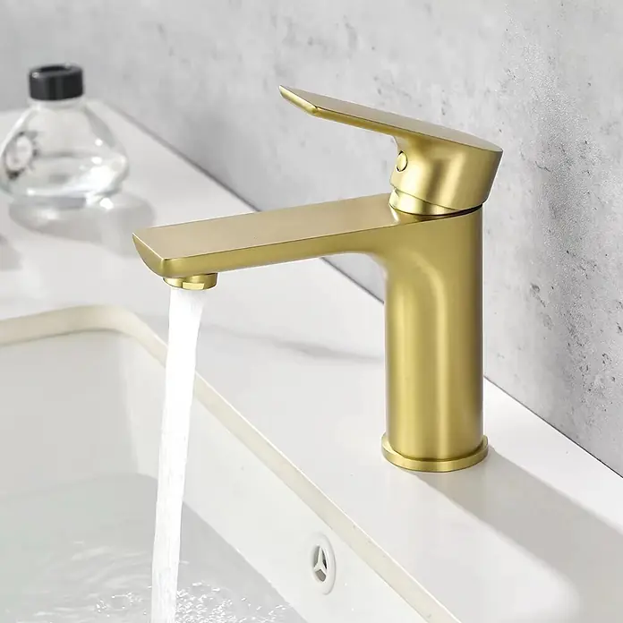 Hudor Waschtischarmatur Scamandre 7277 - Seidenmatt - Gebürstete goldene Badarmatur mit Wasser, das in ein weißes Waschbecken fließt.