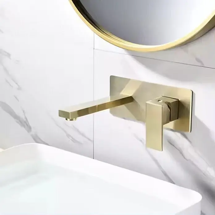 Hudor Waschtischarmatur Scamandre 7291 - Seidenmatt - Goldener Wandarmatur mit flachem Auslauf und Einhebelmischer, über einem weißen rechteckigen Waschbecken montiert.