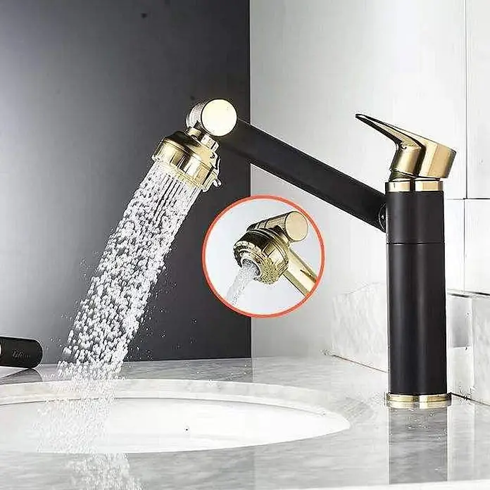 Hudor Waschtischarmatur Scamandre - Seidenmatt - Schwarz-goldene Küchenarmatur mit schwenkbarem Brausekopf, der Wasser in ein weißes Waschbecken sprüht.