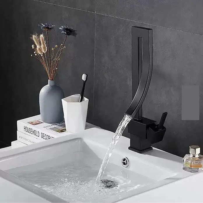 Hudor Waschtischarmatur Alphée - Matt - Schwarze, moderne Armatur gießt Wasser in ein weißes Waschbecken in einem modernen Badezimmer.