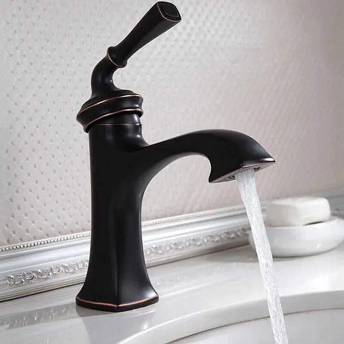 Hudor Waschtischarmatur Céphise 062 - Matt - Dunkle Bronze-Vintage-Armatur mit gebogenem Auslauf und Hebelgriff, die Wasser in ein Waschbecken leitet.