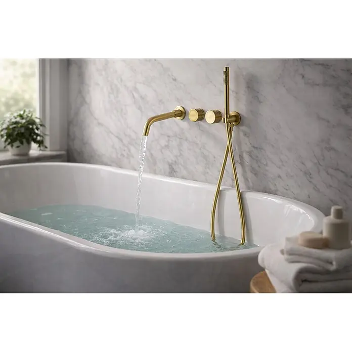 Hudor Badewannenarmatur Scamandre 078 - Seidenmatt - Goldfarbene, wandmontierte Badewannenarmatur befüllt eine weiße Wanne, mit passender Handbrause.