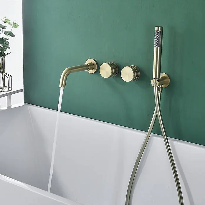 Hudor Badewannenarmatur Scamandre 078 - Seidenmatt - Wandmontierte Badewannenarmatur aus gebürstetem Gold mit fließendem Wasser und passender Handbrause über einer weißen Wanne.