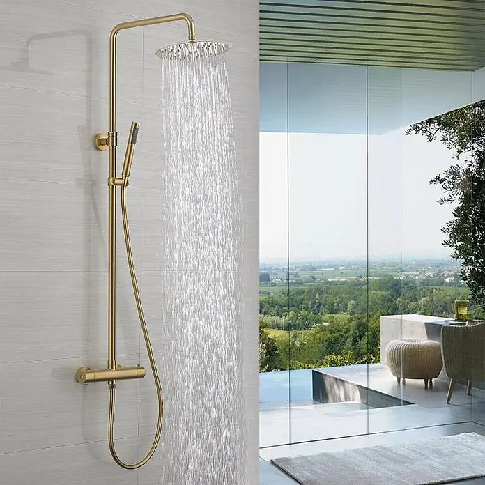 Hudor Duschsystem Scamandre SC418 Thermostat -  - Goldfarbenes Thermostat-Duschsystem mit Regendusche und Handbrause, installiert in einem modernen Bad mit Aussicht.