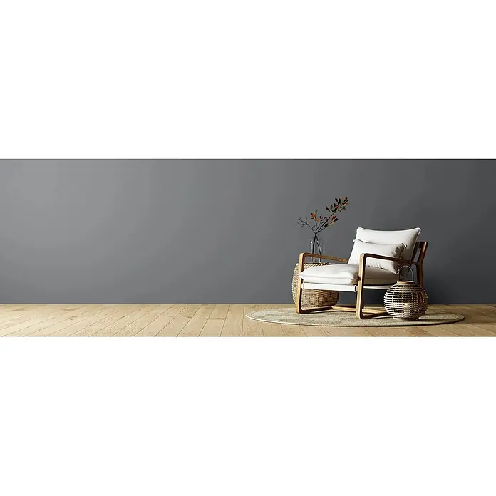 Caleo Color Wandfarbe Lehmfarbe Donnergrollen - Donnergrollen, Matt, 0,15 l - Moderner Sessel mit weißen Kissen, Holzrahmen und Korbflecht-Akzenten auf einem Teppich.
