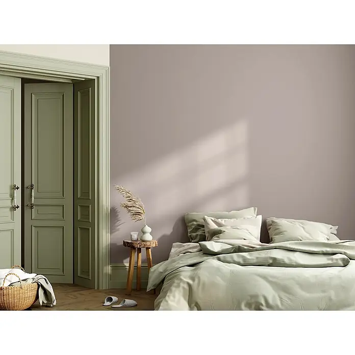 Caleo Color Wandfarbe Lehmfarbe Falkenfeder - Falkenfeder, Matt, 0,15 l - Ein ruhiges Schlafzimmer mit einem Bett mit hellgrüner Bettwäsche, einem rustikalen Holztisch und olivgrünen Türen.