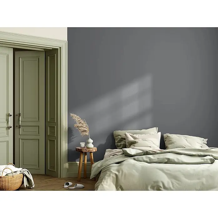 Caleo Color Wandfarbe Lehmfarbe Donnergrollen - Donnergrollen, Matt, 0,15 l - Dunkelgraue Wandfarbe in einem gemütlichen Schlafzimmer mit hellgrünen Türen und Bettwäsche.
