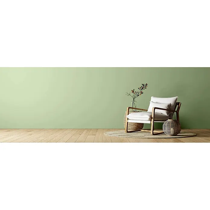 Caleo Color Wandfarbe Lehmfarbe Salbeiduft - Salbeiduft, Matt, 5 l - Minimalistischer Sessel mit hellem Holzrahmen und weißen Kissen in einem Raum.