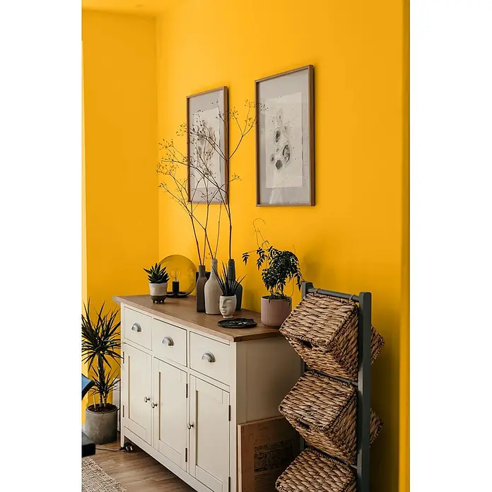 Caleo Color Wandfarbe Lehmfarbe Korallenriff - Korallenriff, Matt, 5 l - Cremefarbenes Sideboard aus Holz mit Naturholzplatte, Schubladen und Schränken, mit Pflanzen und Vasen dekoriert.