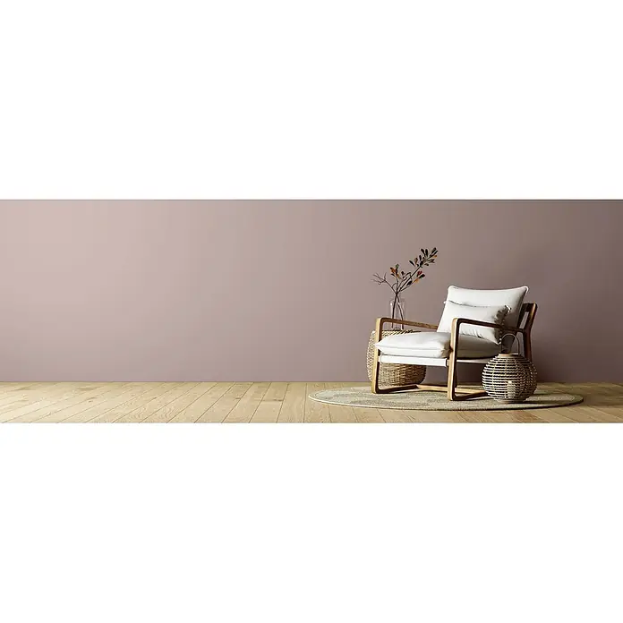 Caleo Color Wandfarbe Lehmfarbe Abenddämmerung - Abenddämmerung, Matt, 0,15 l - Heller Holzsessel mit weißen Kissen, einem runden Teppich und einem Korbtisch sowie einer Laterne in einem gemütlichen Raum.