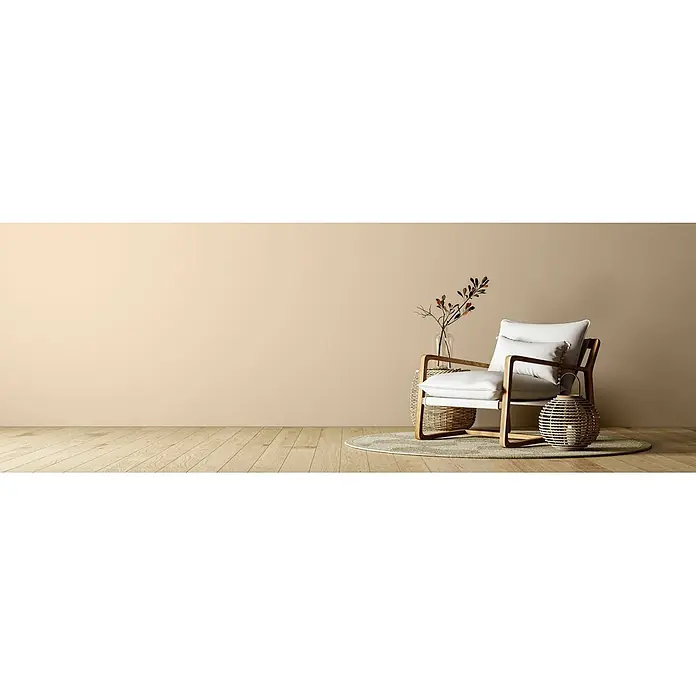 Caleo Color Wandfarbe Lehmfarbe Königsfelsen - Königsfelsen, Matt, 2,25 l - Moderner Sessel mit hellen Polstern und Holzrahmen auf rundem Teppich, daneben Weidenlaterne und Vase mit Zweigen.