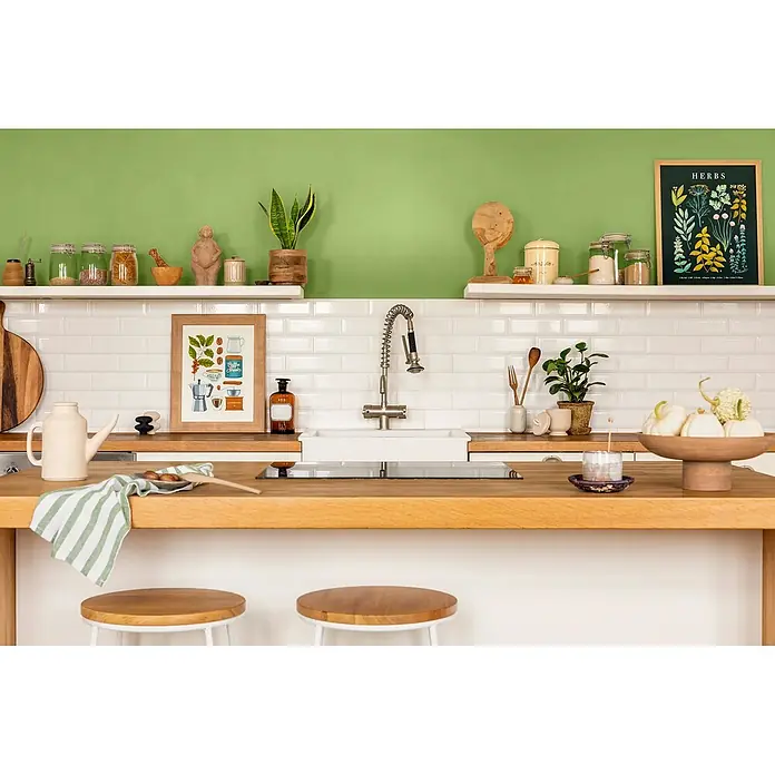 Caleo Color Wandfarbe Lehmfarbe Gingko - Gingko, Matt, 10 l - Weiß-grün gestreiftes Küchentuch über einer Holztheke drapiert.
