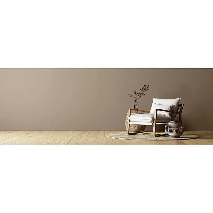 Caleo Color Wandfarbe Lehmfarbe Steineiche - Steineiche, Matt, 0,15 l - Moderner Sessel mit weißen Kissen und Holzrahmen, neben einem Korbtisch mit Vase und einer Korblaterne auf einem runden Teppich.