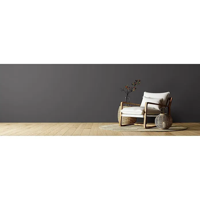 Caleo Color Wandfarbe Lehmfarbe Ebenholz - Ebenholz, Matt, 0,15 l - Moderner Holz-Sessel mit weißen Kissen, einem Rattan-Beistelltisch und einer Rattan-Laterne.