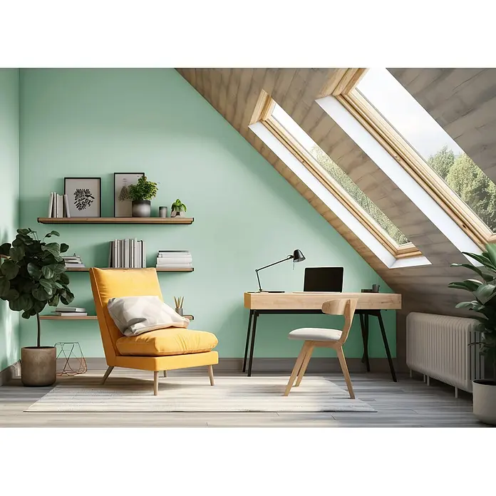 Caleo Color Wandfarbe Lehmfarbe Novembernebel - Novembernebel, Matt, 2,25 l - Helles Dachboden-Homeoffice mit mintgrünen Wänden, Holzschreibtisch, gelbem Sessel und Dachfenstern.