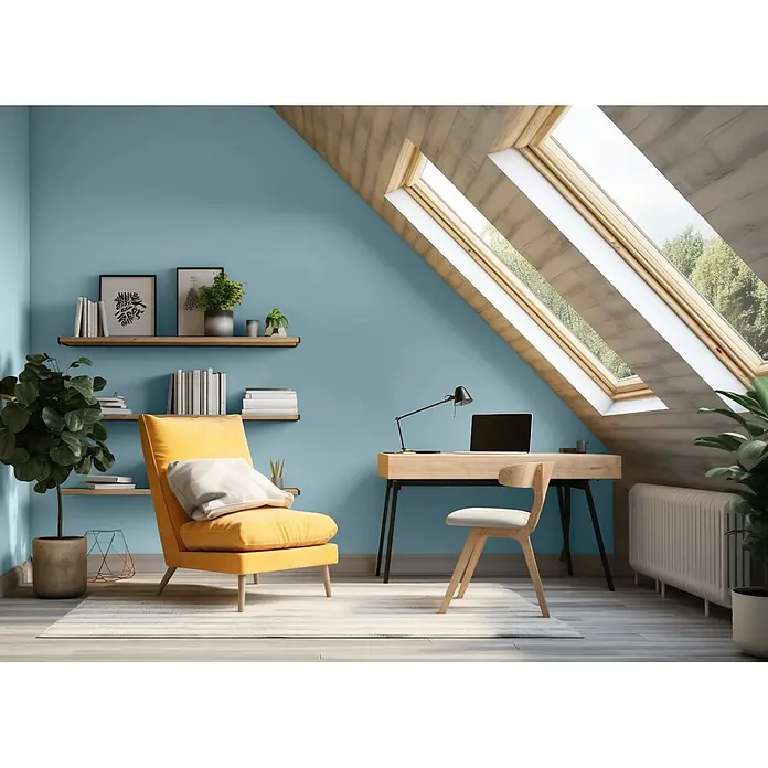 Caleo Color Wandfarbe Lehmfarbe Lagune - Lagune, Matt, 10 l - Dachgeschoss-Büro mit blauer Wand, Holzschreibtisch mit Laptop, passendem Stuhl und gelbem Sessel, beleuchtet durch Dachfenster und dekoriert mit Pflanzen.