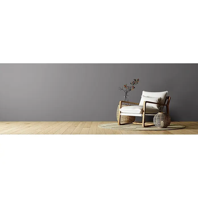 Caleo Color Wandfarbe Lehmfarbe Winternacht - Winternacht, Matt, 5 l - Moderner Holzsessel mit weißen Kissen, ergänzt durch natürliche Flechtelemente und eine Pflanze.