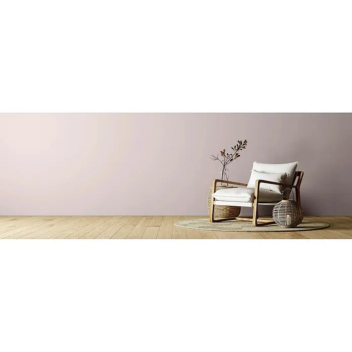 Caleo Color Wandfarbe Lehmfarbe Sternenschweif - Sternenschweif, Matt, 10 l - Weiß gepolsterter Sessel mit Holzrahmen, neben einem geflochtenen Beistelltisch und einer Laterne, in einem minimalistischen Raum.
