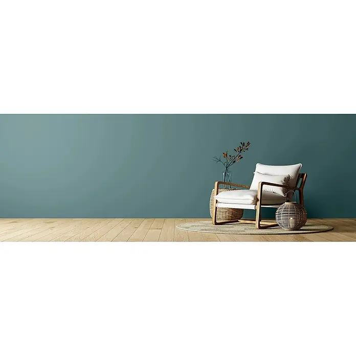 Caleo Color Wandfarbe Lehmfarbe Bergsee - Bergsee, Matt, 0,15 l - Heller Holz-Sessel mit weißen Polstern, ergänzt durch einen Korbtisch und eine Laterne, auf einem Teppich in einem modernen Raum.