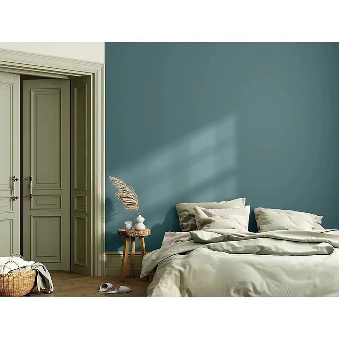 Caleo Color Wandfarbe Lehmfarbe Bergsee - Bergsee, Matt, 0,15 l - Ruhiges Schlafzimmer mit teal Wand, olivgrünen Kassettentüren, hellgrüner Bettwäsche und kleinem Nachttisch aus Holz.
