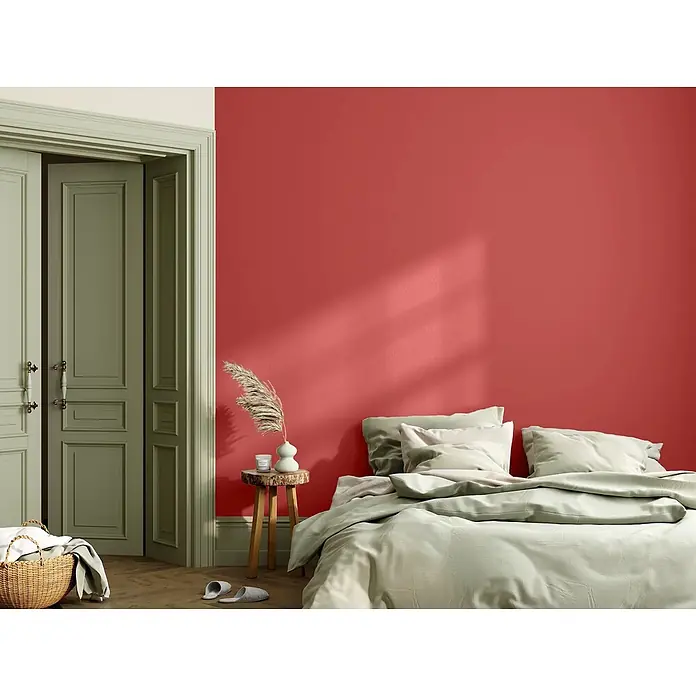 Caleo Color Wandfarbe Lehmfarbe Mohnblume - Mohnblume, Matt, 2,25 l - Schlafzimmer mit roter Akzentwand, hellgrüner Bettwäsche und salbeigrünen Türen.