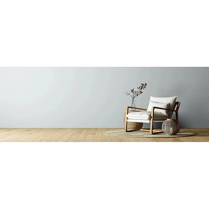Caleo Color Wandfarbe Lehmfarbe Schäfchenwolke - Schäfchenwolke, Matt, 0,15 l - Moderner Sessel mit cremefarbenen Polstern und Holzrahmen, auf einem Teppich in einem minimalistischen Raum mit Naturdeko.