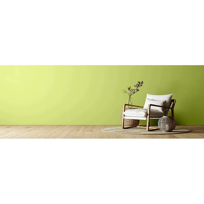 Caleo Color Wandfarbe Lehmfarbe Urzeitfarn - Urzeitfarn, Matt, 5 l - Moderner Sessel mit weißen Kissen, Rattan-Beistelltisch mit Vase und dekorative Rattanlaterne auf einem Teppich.