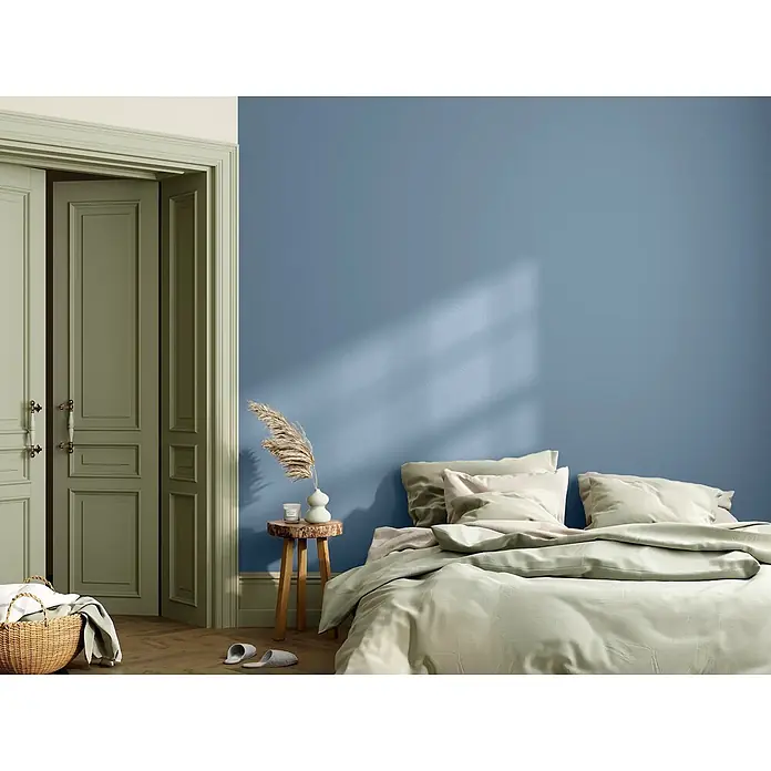 Caleo Color Wandfarbe Lehmfarbe Morgennebel - Morgennebel, Matt, 5 l - Ruhiges Schlafzimmer mit blauer Wand, salbeigrünen Türen und hellgrüner Bettwäsche.