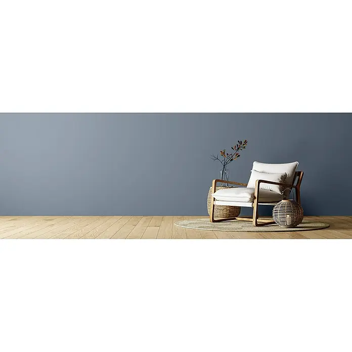 Caleo Color Wandfarbe Lehmfarbe Wolkenbett - Wolkenbett, Matt, 0,15 l - Moderner Sessel mit hellem Holzrahmen und cremefarbenen Kissen, dekoriert mit Beistelltisch, Vase und Laterne auf einem Teppich.