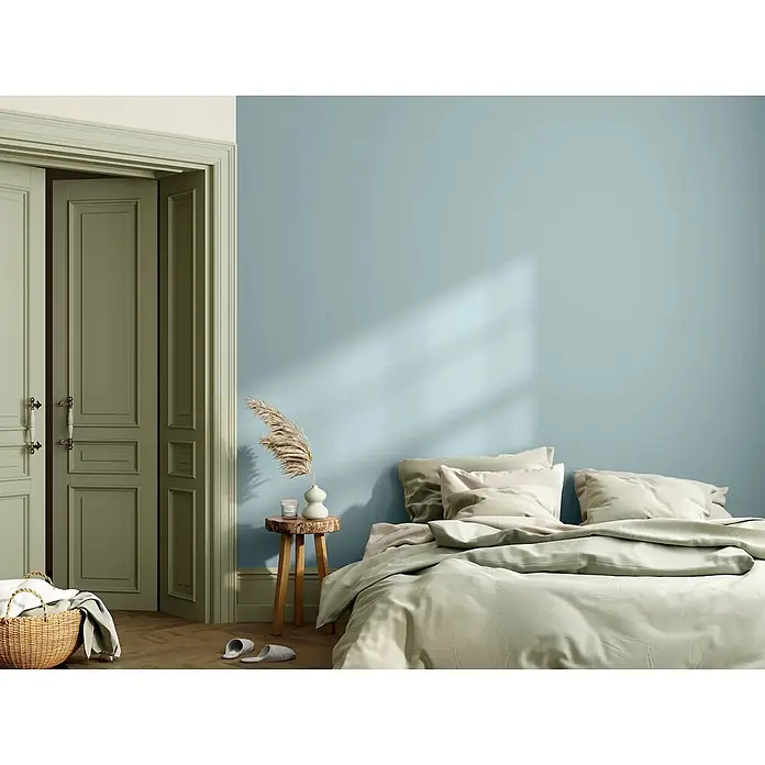 Caleo Color Wandfarbe Lehmfarbe Eisenherz - Eisenherz, Matt, 0,15 l - Ein ruhiges Schlafzimmer mit hellblauer Wand, olivgrünen Türen und weicher hellgrüner Bettwäsche, das eine beruhigende Atmosphäre schafft.