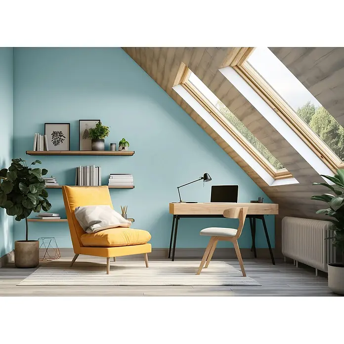 Caleo Color Wandfarbe Lehmfarbe Eisenherz - Eisenherz, Matt, 0,15 l - Helles Dachgeschoss-Büro mit hellem Holzschreibtisch und Stuhl, gemütlichem gelbem Sessel und schwebenden Regalen an einer blauen Wand.