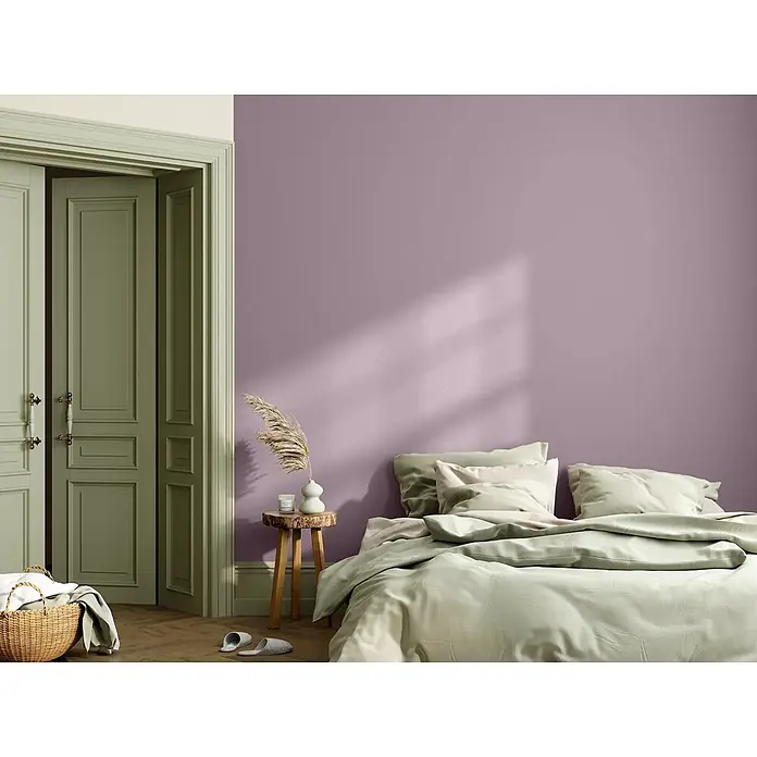 Caleo Color Wandfarbe Lehmfarbe Traumfänger - Traumfänger, Matt, 5 l - Ein gemütliches Schlafzimmer mit einer hellvioletten Wand, salbeigrünen Doppeltüren und hellgrüner Bettwäsche auf einem Holzboden.