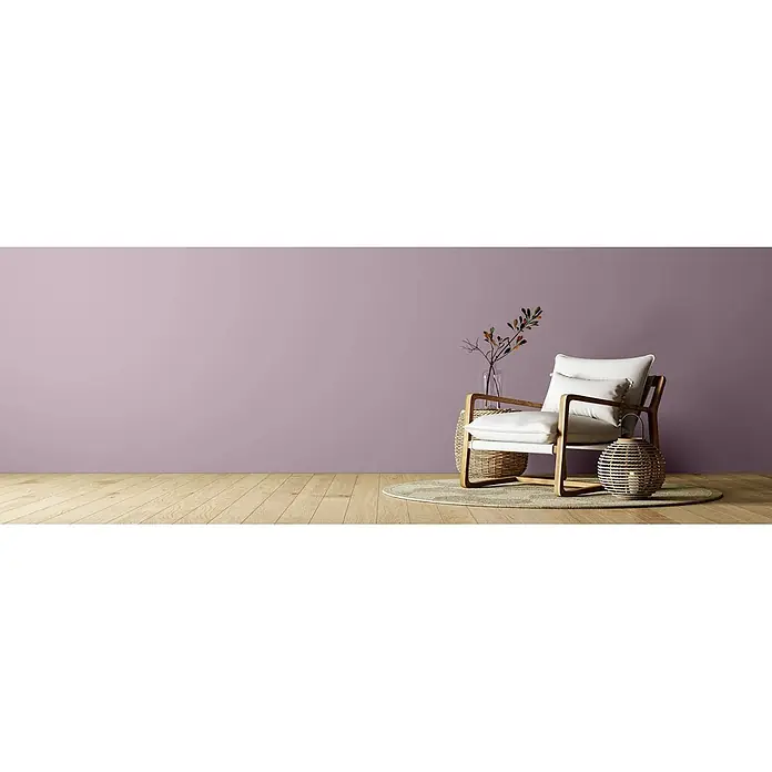 Caleo Color Wandfarbe Lehmfarbe Traumfänger - Traumfänger, Matt, 5 l - Ein moderner Sessel mit hellem Holzrahmen und weißen Kissen, auf einem runden Teppich in einem Raum mit lila Wand.