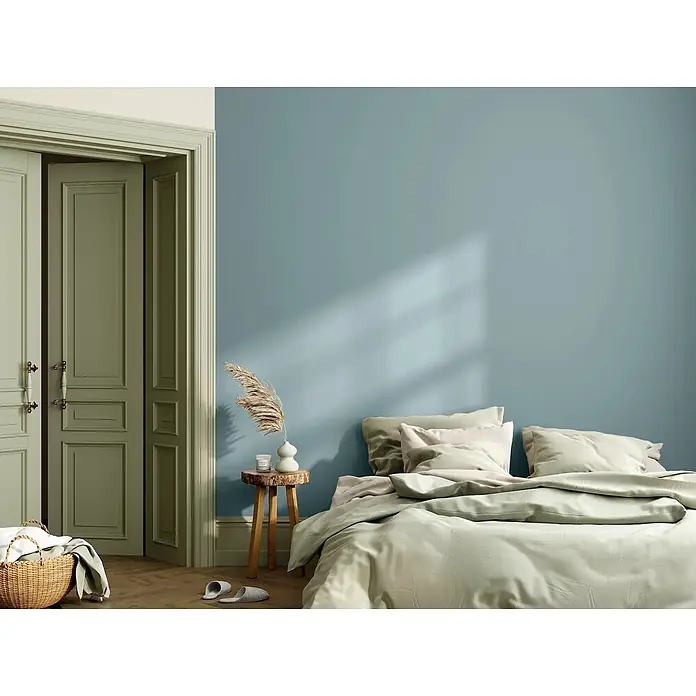 Caleo Color Wandfarbe Lehmfarbe Traumsand - Traumsand, Matt, 2,25 l - Ein gemütliches Schlafzimmer mit staubblauen Wänden, salbeigrünen Türen und hellgrüner Bettwäsche.