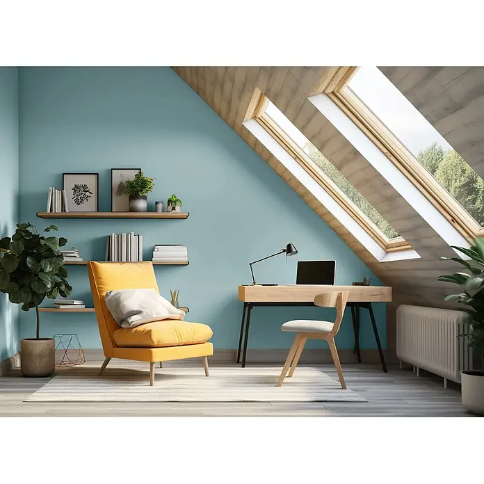 Caleo Color Wandfarbe Lehmfarbe Traumsand - Traumsand, Matt, 2,25 l - Modernes Dachzimmer mit hellblauen Wänden, einem gelben Sessel und einem Holzschreibtisch unter Dachfenstern.