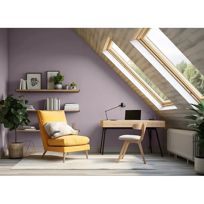 Caleo Color Wandfarbe Lehmfarbe Lavendel - Lavendel, Matt, 0,15 l - Ein einladendes Dachzimmer mit fliederfarbenen Wänden, einem gemütlichen gelben Sessel, einem Holzschreibtisch und Dachfenstern, als helles Home-Office und Entspannungsbereich.