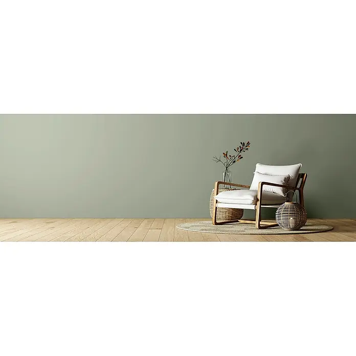 Caleo Color Wandfarbe Lehmfarbe Schilf - Schilf, Matt, 10 l - Moderner Sessel mit hellen Polstern und Holzrahmen, auf einem runden Teppich in einem Raum mit Holzboden.