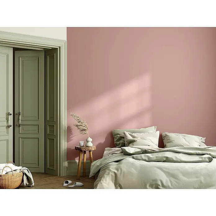 Caleo Color Wandfarbe Lehmfarbe Magnolie - Magnolie, Matt, 0,15 l - Schlafzimmer mit rosa Wand und hellgrüner Bettwäsche, Türrahmen und Türen.