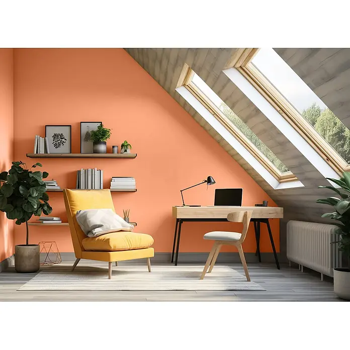Caleo Color Wandfarbe Lehmfarbe Papaya - Papaya, Matt, 0,15 l - Modernes Dachbüro mit orangen Wänden, hellem Holzschreibtisch, Stuhl, gelbem Sessel und Dachfenstern.