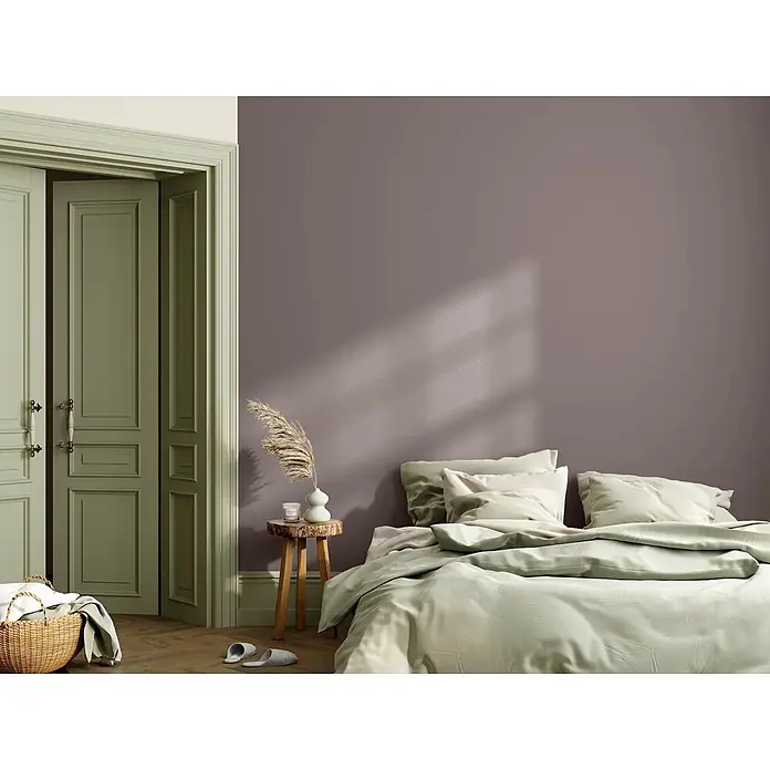 Caleo Color Wandfarbe Lehmfarbe Baumrinde - Baumrinde, Matt, 2,25 l - Gemütliches Schlafzimmer mit hellgrüner Bettwäsche, einer malvenfarbenen Wand und salbeigrünen Türen.