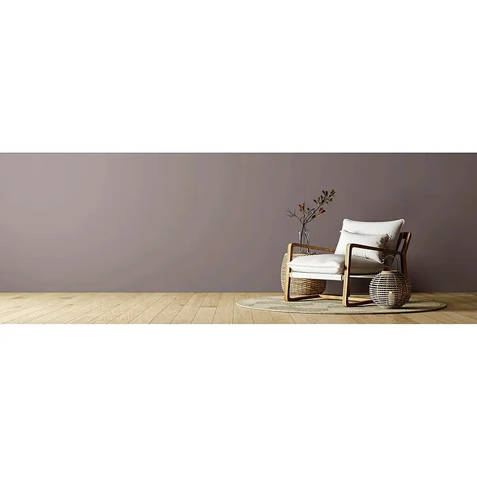 Caleo Color Wandfarbe Lehmfarbe Baumrinde - Baumrinde, Matt, 2,25 l - Moderner Sessel mit hellem Holzrahmen und weißen Kissen, ergänzt durch geflochtene Rattandeko, in einem modernen Ambiente.