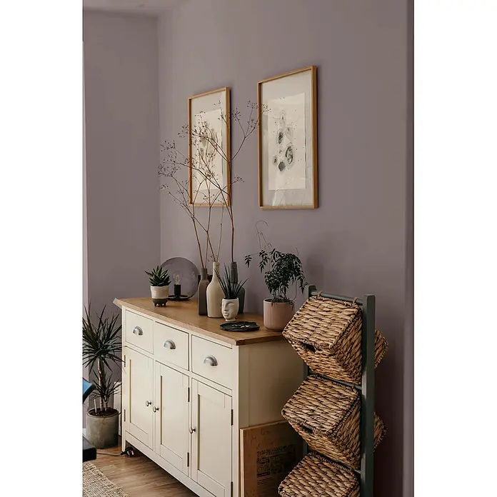 Caleo Color Wandfarbe Lehmfarbe Baumrinde - Baumrinde, Matt, 2,25 l - Cremefarbenes Holzbuffet mit Naturholzplatte, Muschelgriffen und Schränken, dekoriert mit Pflanzen und Kunst.