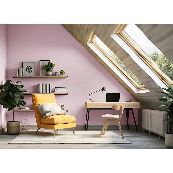 Caleo Color Wandfarbe Lehmfarbe Blütenzauber - Blütenzauber, Matt, 5 l - Gemütliches Dachgeschoss-Büro mit rosa Wänden, Holzschreibtisch, gelbem Sessel und Dachfenstern, ein heller und funktionaler Arbeitsbereich.