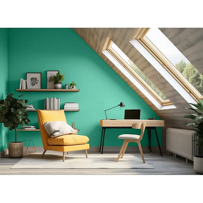 Caleo Color Wandfarbe Lehmfarbe Smaragd - Smaragd, Matt, 0,15 l - Helles Dachboden-Heimbüro mit grüner Wand, Holzschreibtisch, Stuhl und gelbem Sessel unter Dachfenstern.