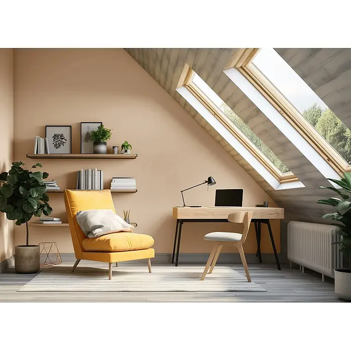 Caleo Color Wandfarbe Lehmfarbe Samtpfote - Samtpfote, Matt, 10 l - Gemütlicher Dachboden-Arbeitsbereich mit hellem Holzschreibtisch, schwarzer Lampe und leuchtendem gelben Sessel, beleuchtet durch Oberlichtfenster.