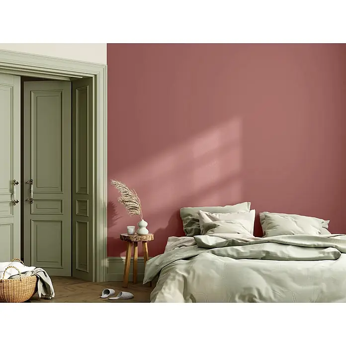 Caleo Color Wandfarbe Lehmfarbe Sommerabend - Sommerabend, Matt, 2,25 l - Weiche, hellgrüne Bettwäsche auf einem Bett in einem ruhigen Schlafzimmer.