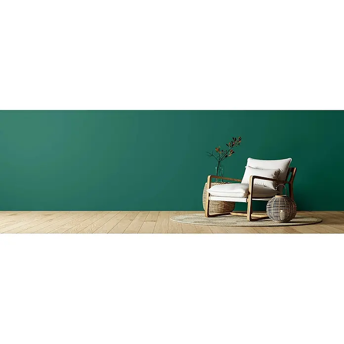 Caleo Color Wandfarbe Lehmfarbe Palmenblatt - Palmenblatt, Matt, 2,25 l - Sessel mit hellem Holzrahmen und weißen Kissen, auf einem Teppich mit geflochtenen Dekoelementen.