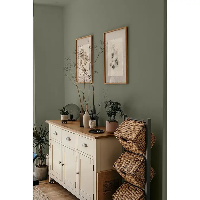 Caleo Color Wandfarbe Lehmfarbe Rosmarin - Rosmarin, Matt, 5 l - Cremefarbenes Holzsideboard mit Naturholzplatte, Schubladen und Schränken, zur Aufbewahrung in einem Raum.