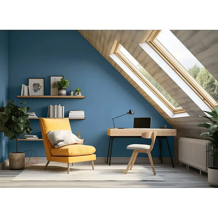 Caleo Color Wandfarbe Lehmfarbe Tiefsee - Tiefsee, Matt, 0,15 l - Ein Dachzimmer mit blauen Wänden, gelbem Sessel und Holzschreibtisch mit Laptop unter Oberlichtern.
