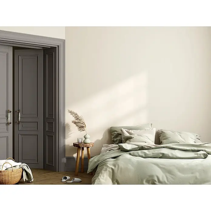 Caleo Color Buntlack Wildkatze - Wildkatze, Seidenmatt, 0,15 l, Wasserbasiert - Ein Bett in einem modernen Schlafzimmer mit hellgrünem Bettbezug und Kissen, beleuchtet von natürlichem Licht.